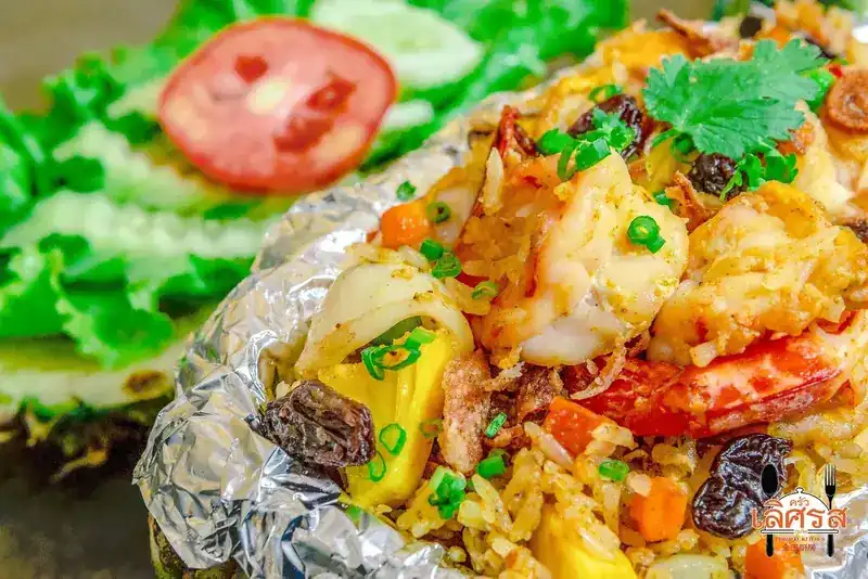 Pineapple fried rice with prawns and raisins, wrapped in foil