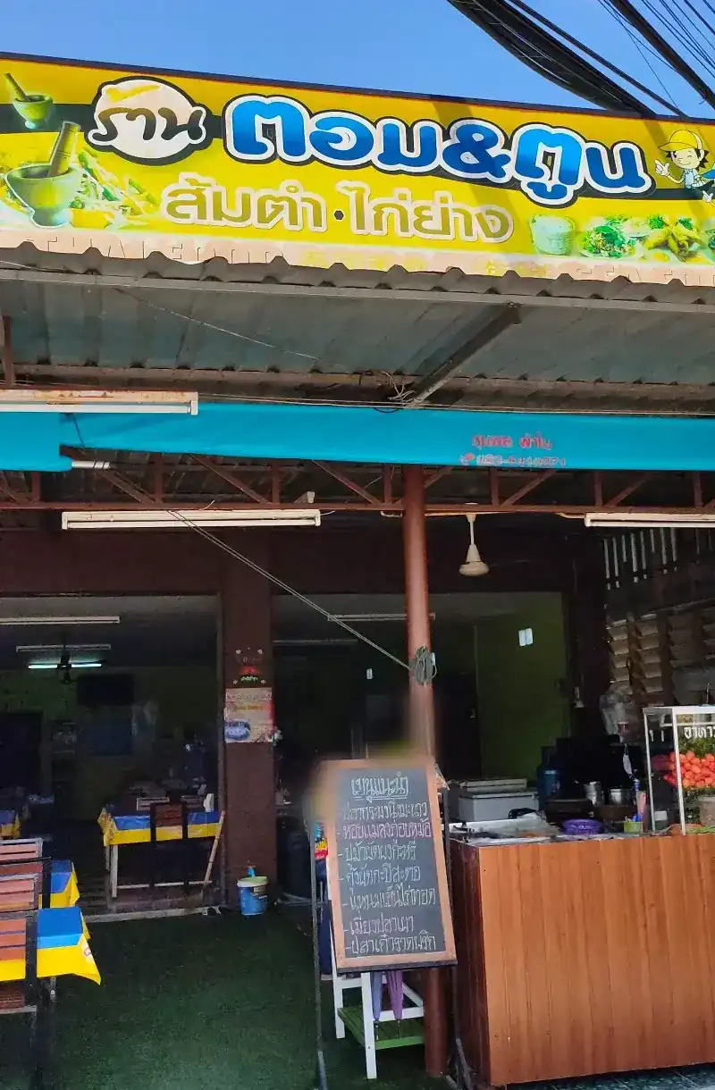 The shop front under the yellow Tom & Toon sign, with a chalkboard by the door