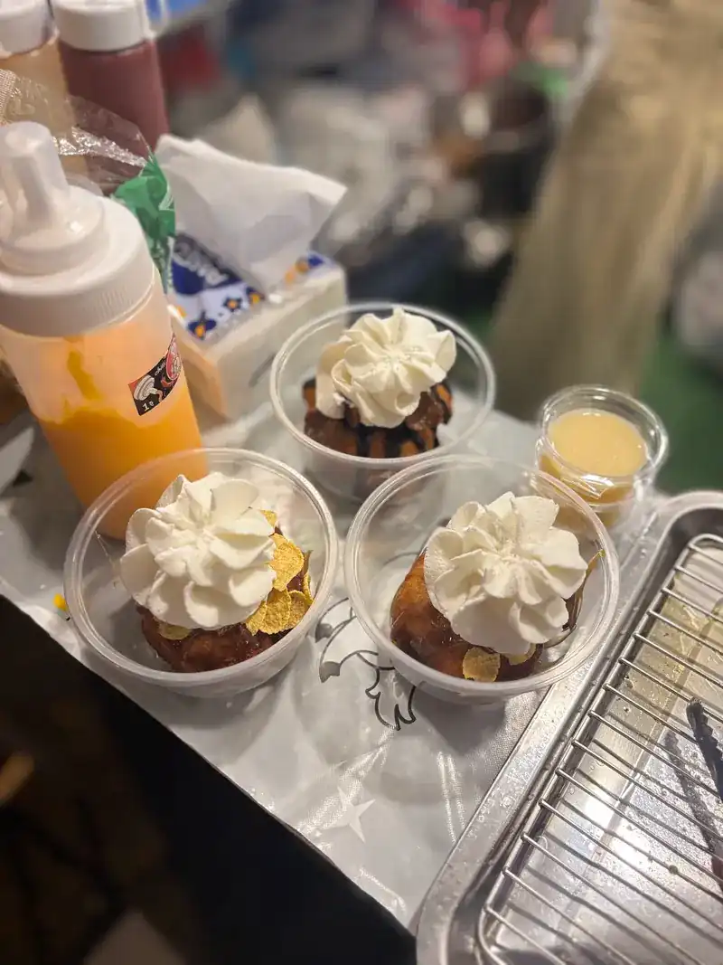 Three cups of dessert topped with whipped cream, lined up on the counter