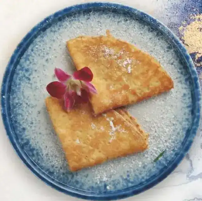 Two folded sugar crêpes on a blue plate