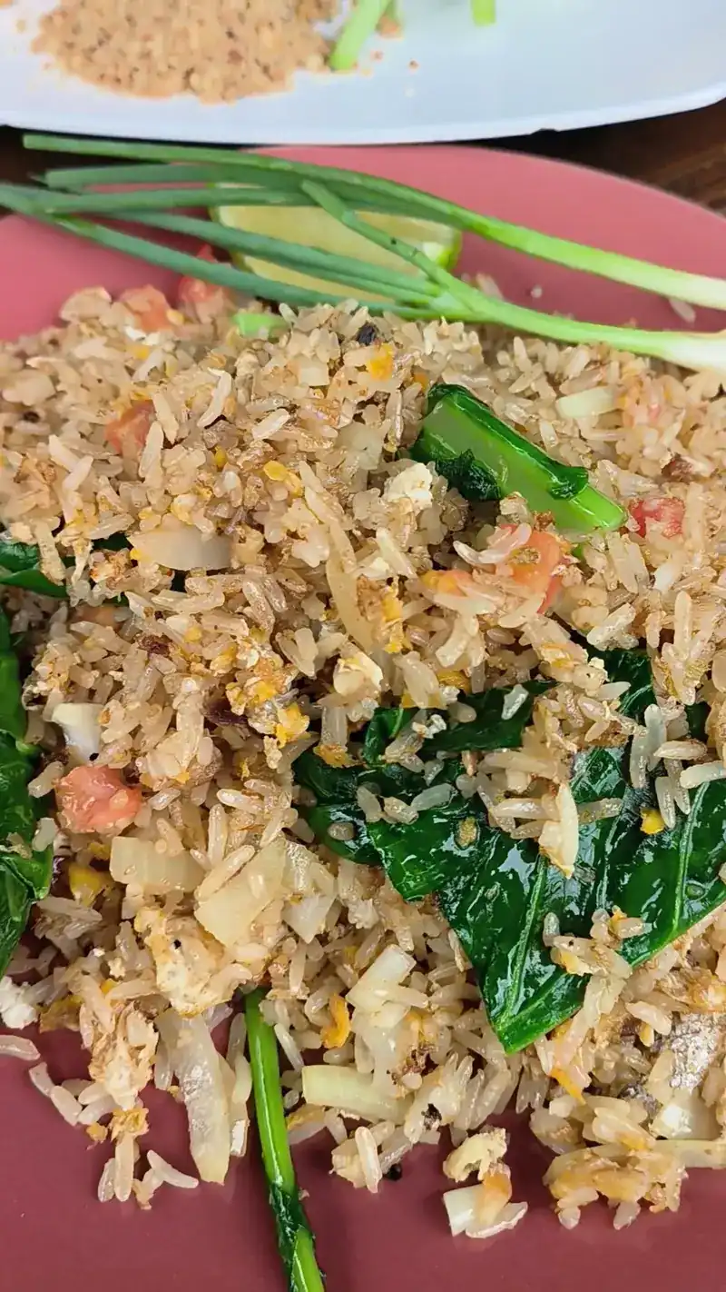 Fried rice with green vegetables on a pink plate