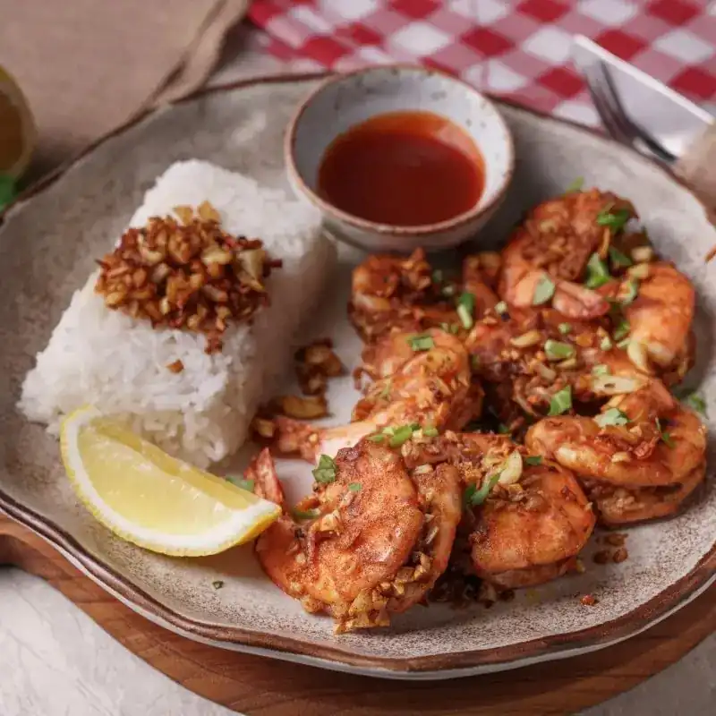 Fried prawns with rice, crispy garlic and a wedge of lemon