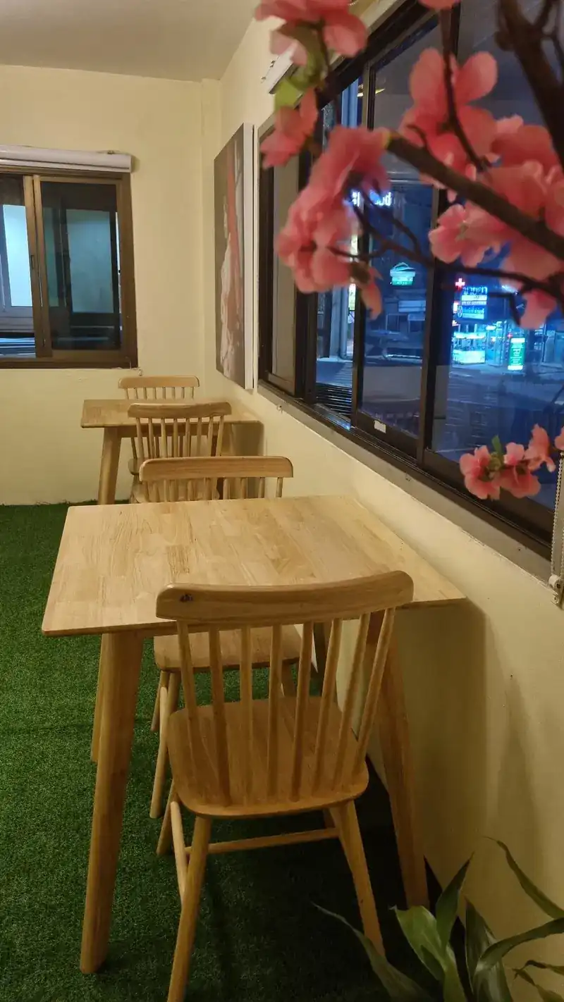 Small side room with wooden tables and cherry blossom by the window
