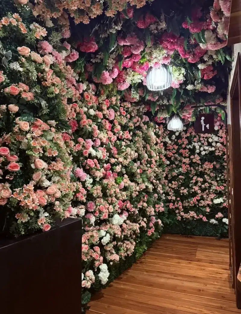 A wall and ceiling covered in pink and white flowers inside the restaurant