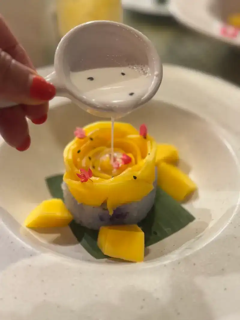 Mango sticky rice, the mango cut into a rose, coconut cream poured over it