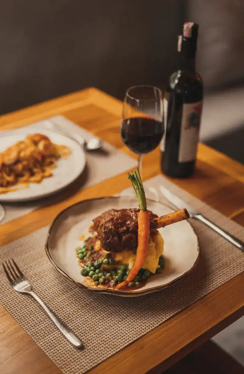 A braised shank on mash and peas, with a whole carrot from the garden