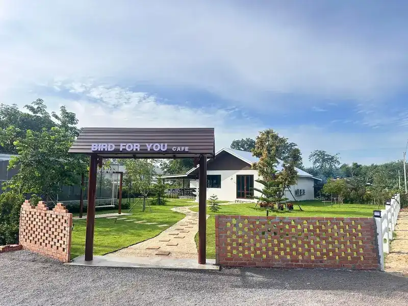 The Bird For You gate, with a stepping-stone path across the lawn to the house