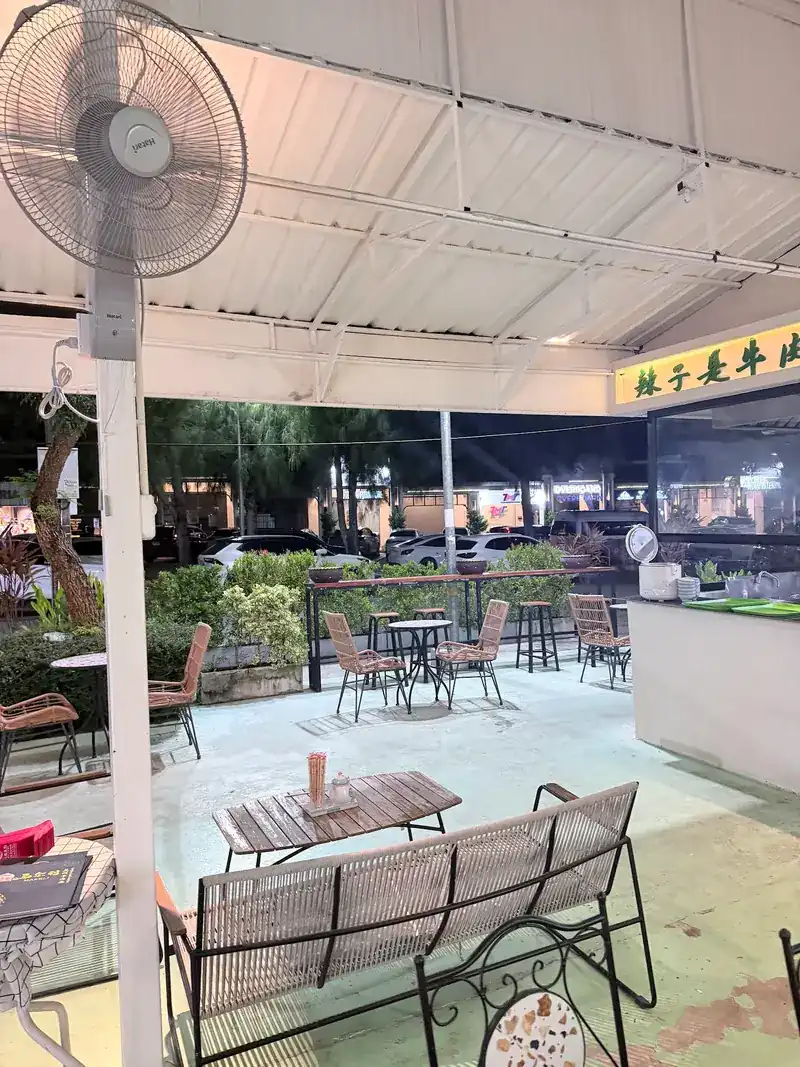 The covered terrace in the evening, with rattan chairs and small tables