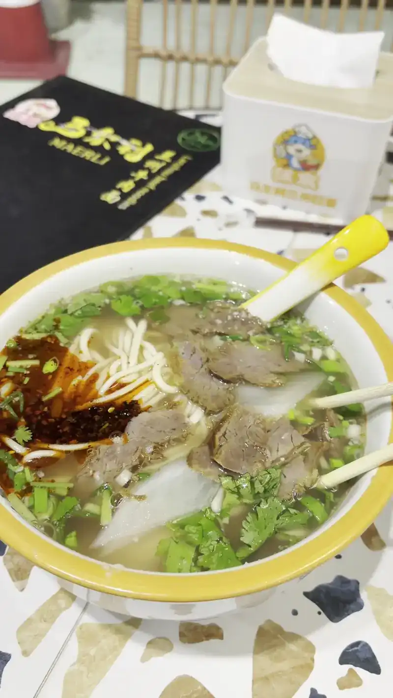 Beef noodle soup with sliced beef, white radish, chili oil and coriander