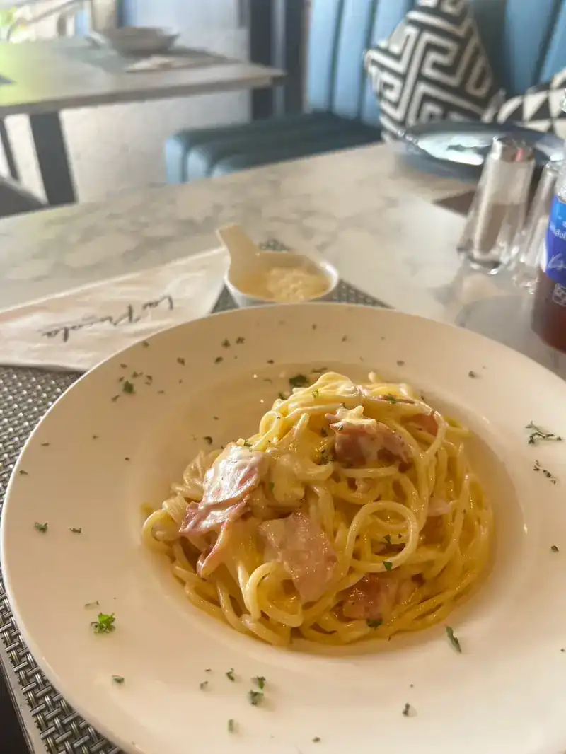 Spaghetti in a creamy sauce in a wide white bowl