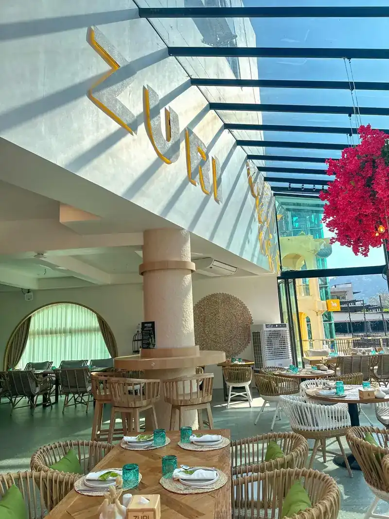 The Zuri name in gold letters on the wall under the glass roof