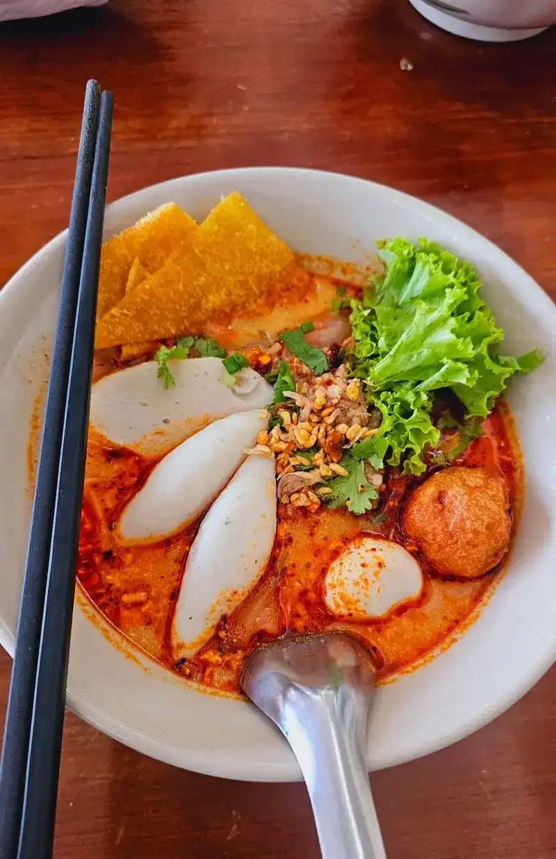 Tom yum noodle soup with fish balls, fish cake slices and a crisp wonton sheet