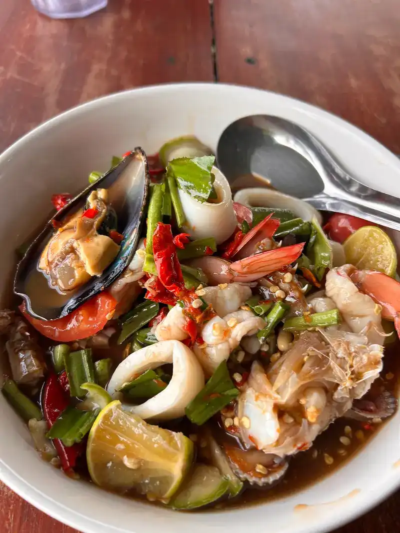 A bowl of spicy seafood with mussels, squid, prawns and lime