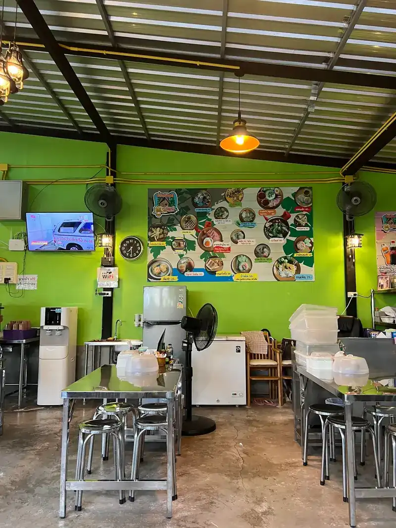 The dining room: lime-green walls, steel tables and stools, wall fans