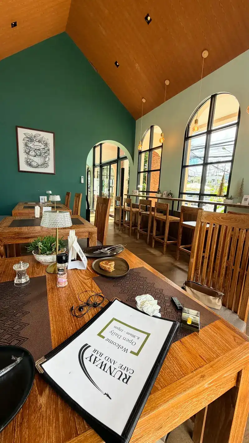 Teal walls, arched windows and wooden tables set for guests