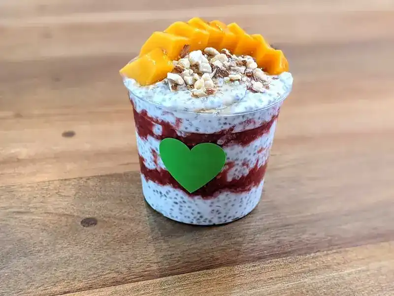 Layered chia pudding in a cup, topped with mango and nuts