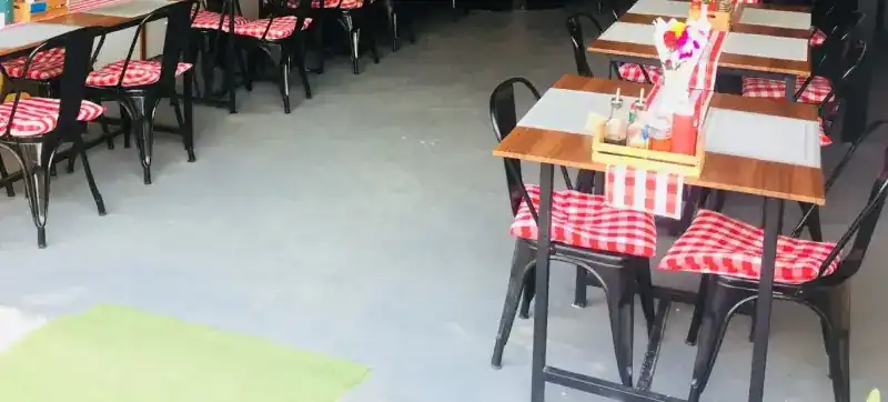 Wooden tables and black chairs with red-and-white check cushions