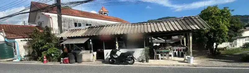 The shop from across the road on Soi Cherngtalay 14: a long, low roof with tables at the side