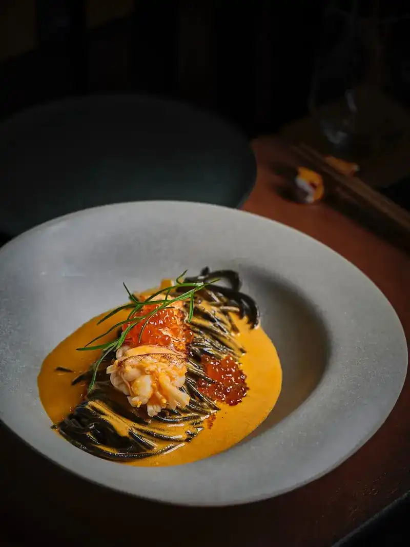 Black spaghetti with lobster and orange roe in a bright sauce / สปาเก็ตตี้ดำกับกุ้งมังกรและไข่ปลาในซอสสีส้ม