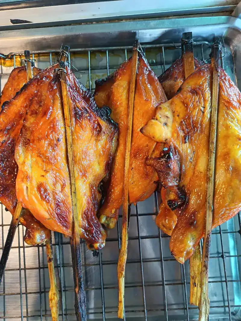Grilled chicken held in split bamboo skewers / ไก่ย่างหนีบไม้ไผ่