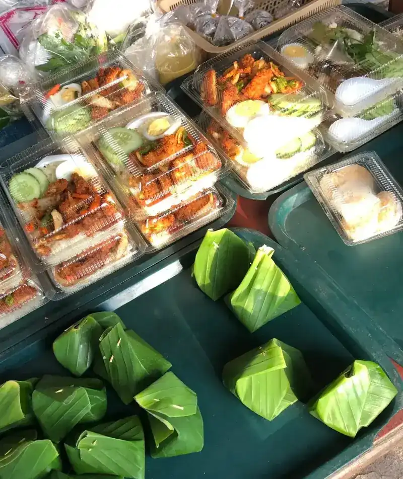 Boxed rice meals and banana-leaf parcels laid out on the counter