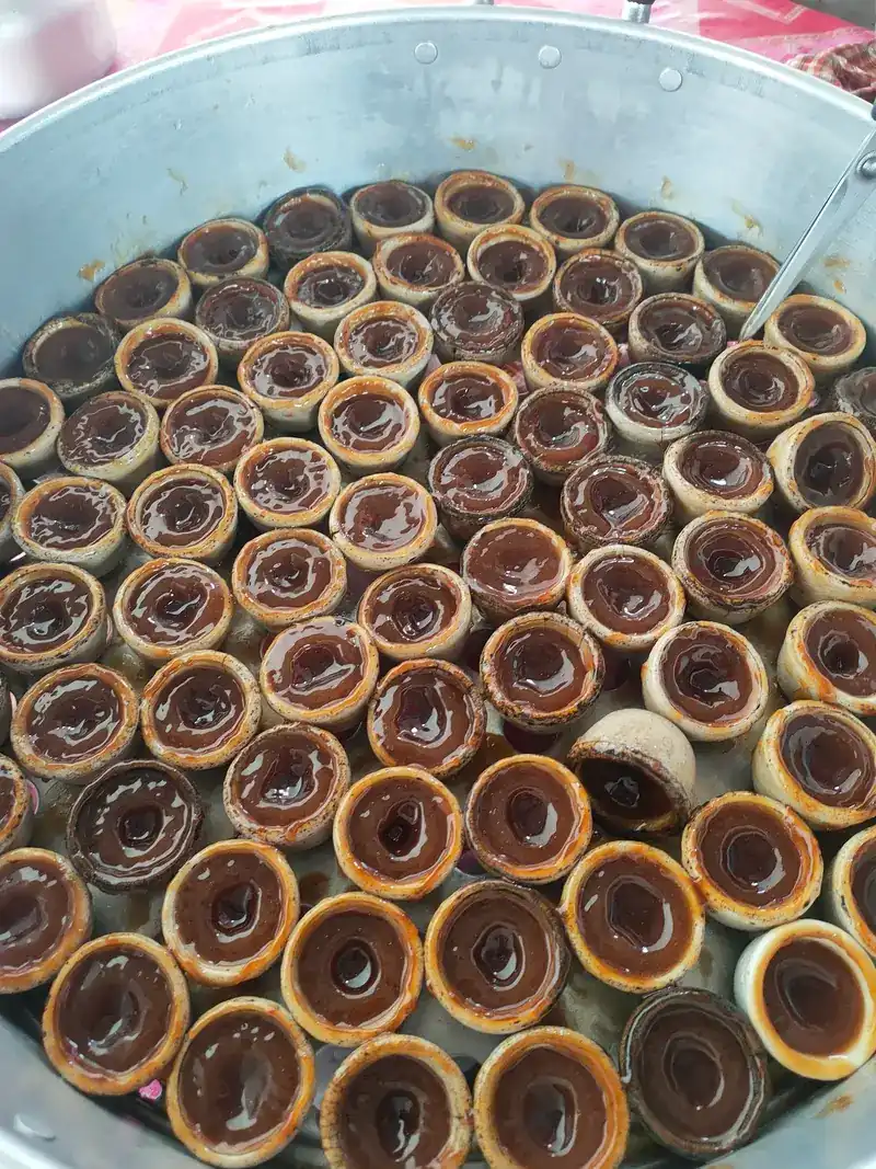A round pan packed with little cups of khanom