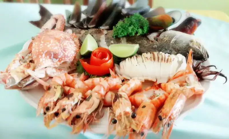 A seafood platter with prawns, crab, squid and mussels, and a tomato rose