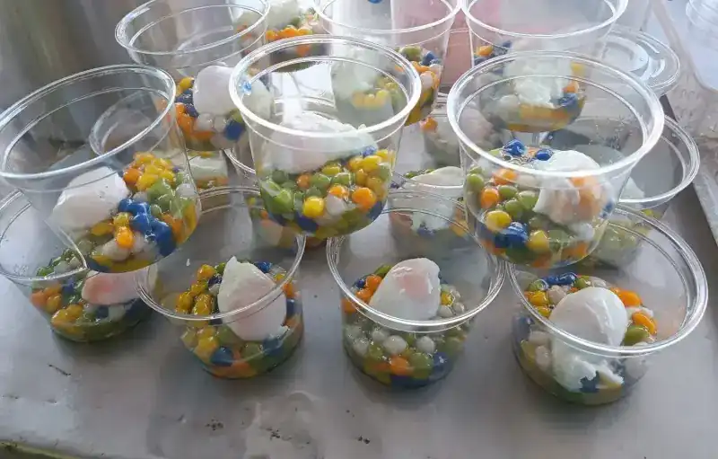 Cups of small coloured balls, each topped with an egg