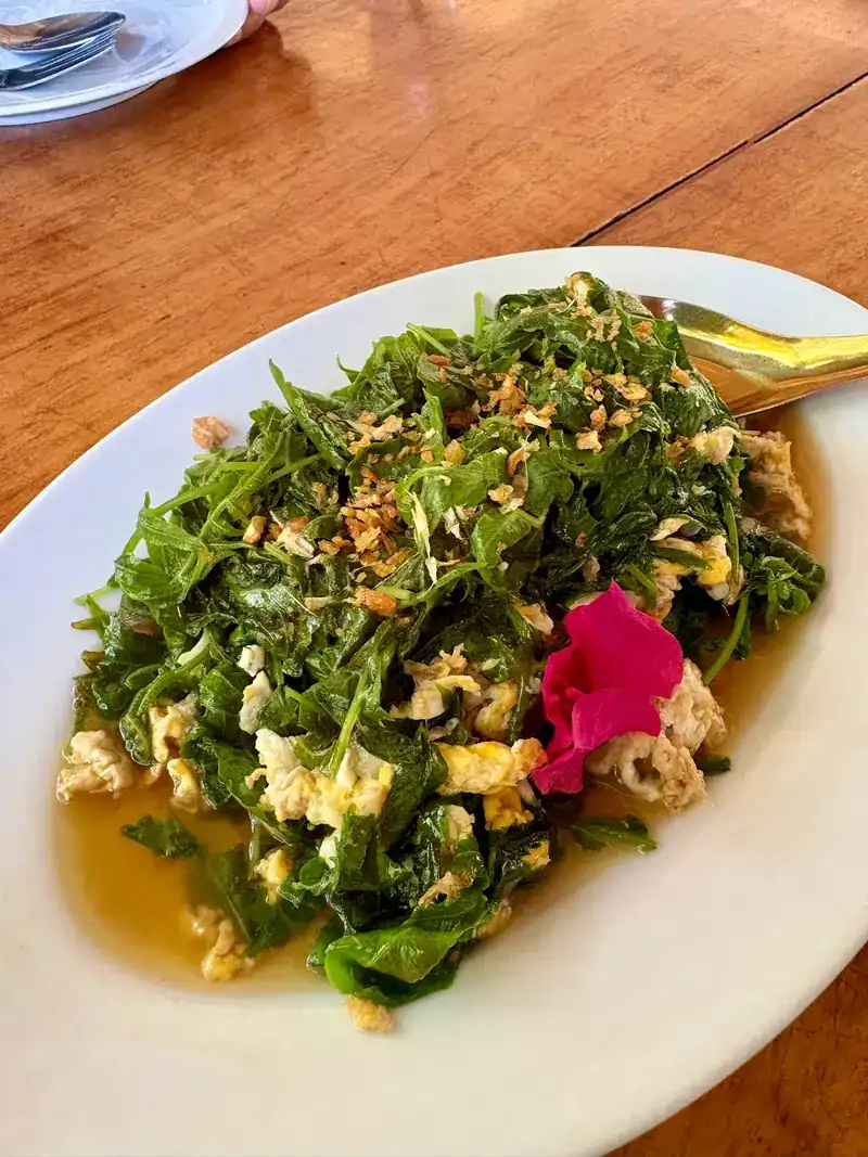 Stir-fried leafy greens with egg on a white plate