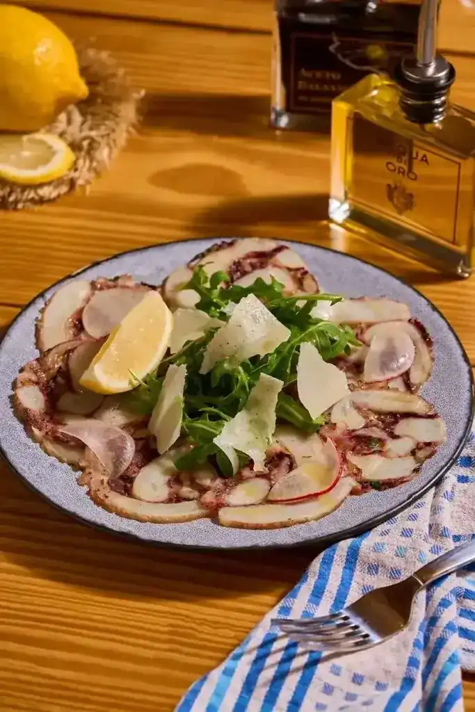 Thinly sliced octopus with rocket, shaved cheese and lemon