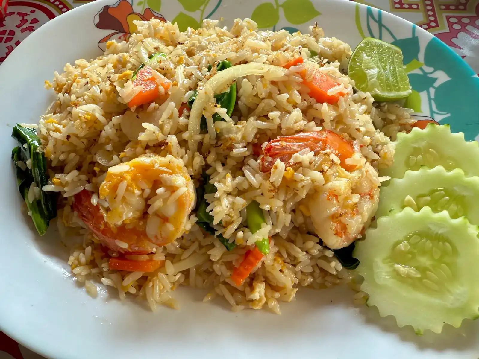 Fried rice with prawns, carrot and Chinese kale, served with lime and cucumber