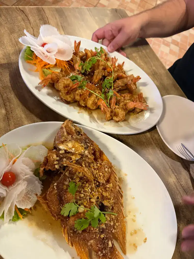 Prawns in a glossy sauce and a whole fried fish with crispy garlic and coriander