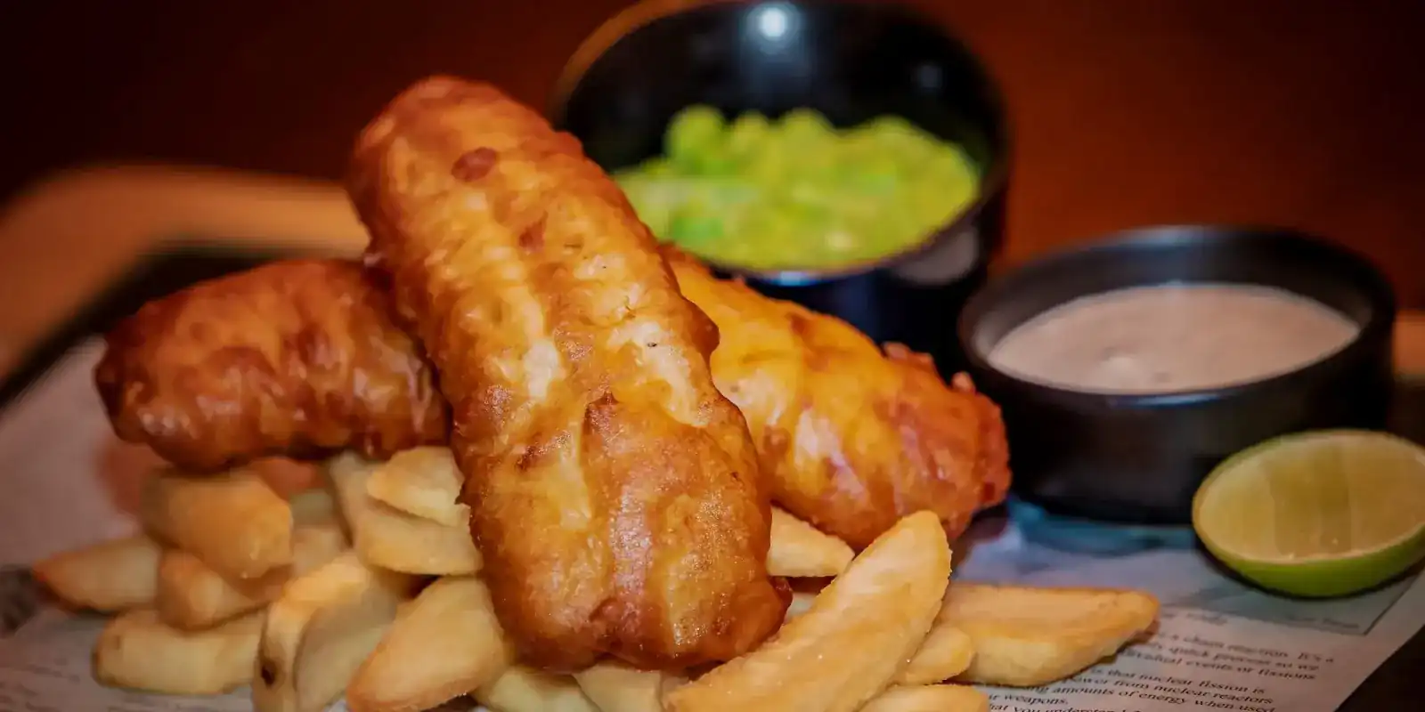 Fish and chips in beer batter with mushy peas, tartar sauce and lime
