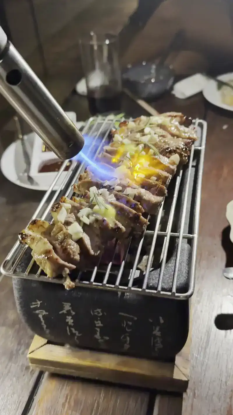 Sliced beef on a small HIDA grill, finished with a torch flame