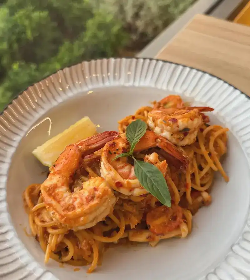 Spaghetti with prawns, basil and a wedge of lemon