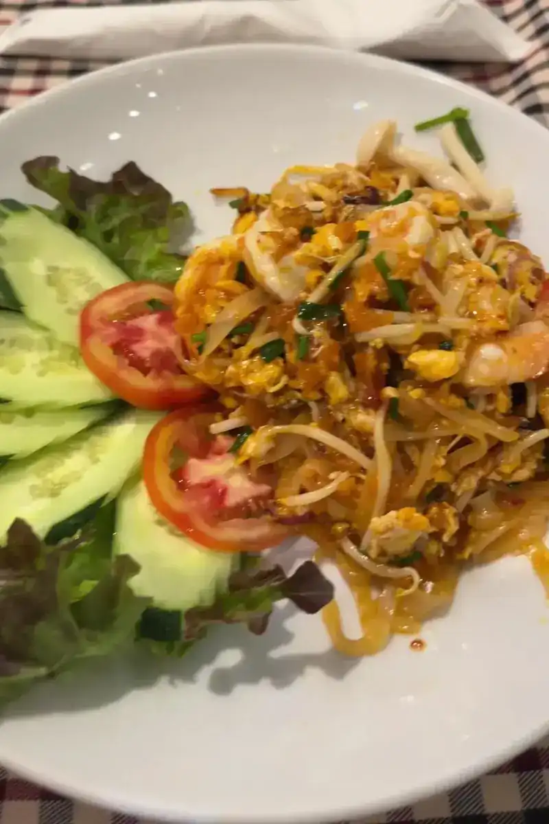 Pad thai with shrimp, with sliced cucumber, tomato and lettuce on the side