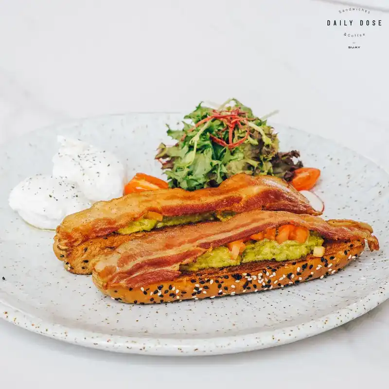 Smashed avocado with bacon and poached eggs on a seeded multigrain bun / อะโวคาโดบดกับเบคอนและไข่โพชบนขนมปังมัลติเกรน