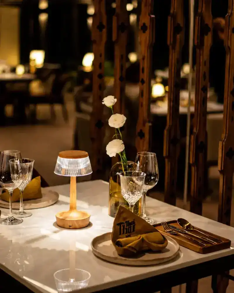 A table by lamplight beside the carved wooden screens