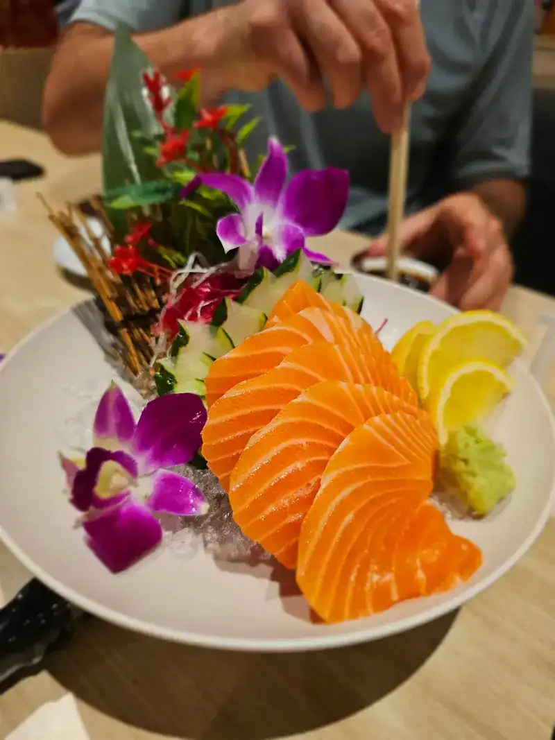 Salmon sashimi with lemon, wasabi and purple orchids