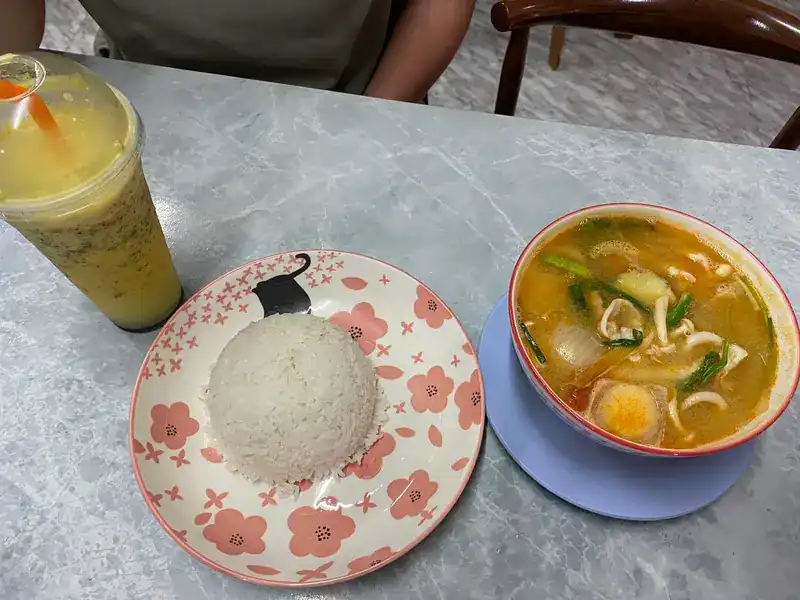 Tom yum soup with seafood, a plate of rice and a fruit shake