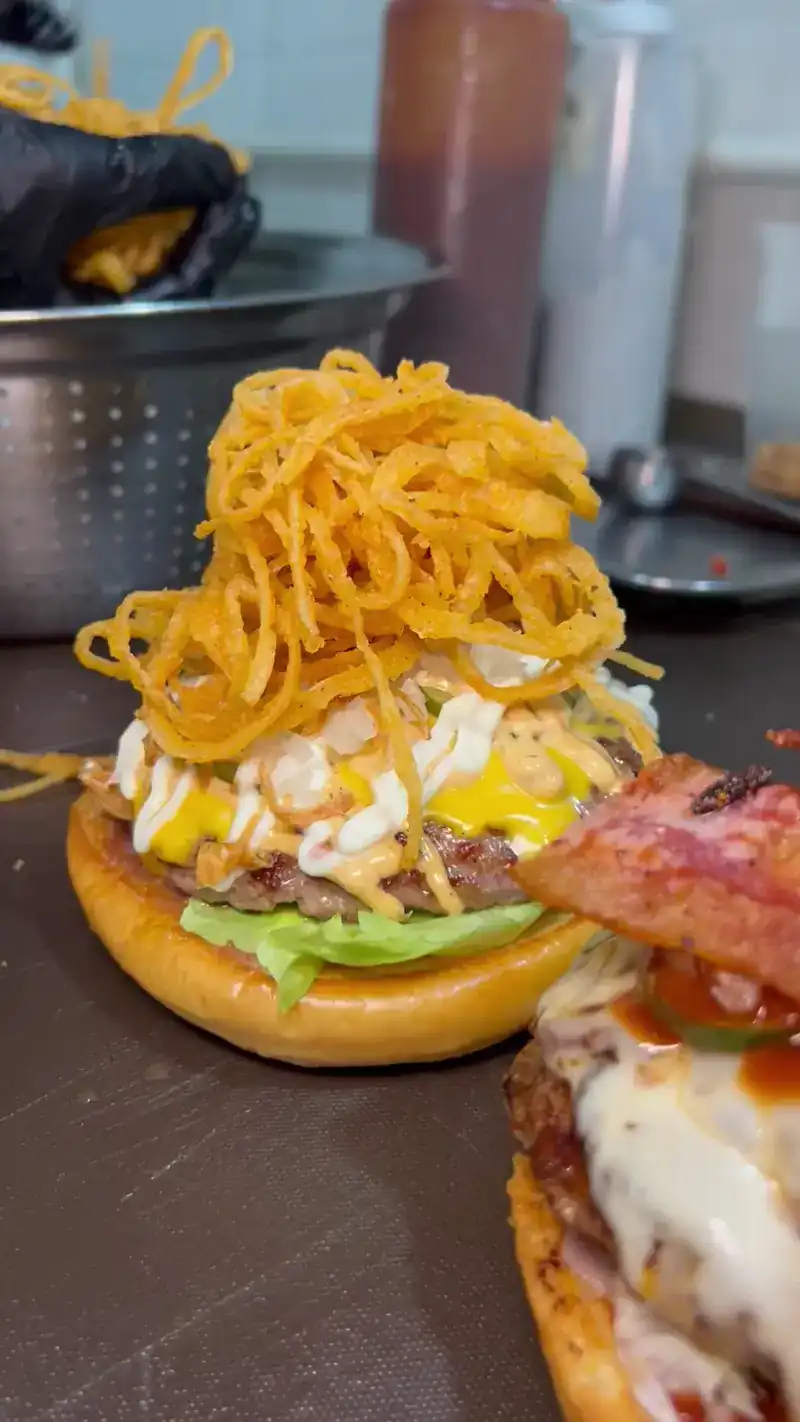 Burger piled high with crispy fried onions / เบอร์เกอร์โปะหอมทอดกรอบสูงเต็มชิ้น