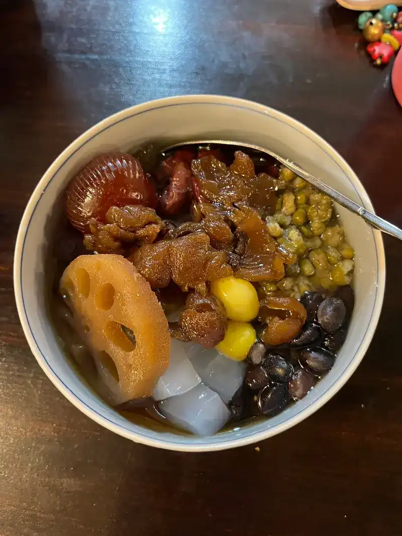 A bowl of lotus root, ginkgo nuts, mung beans and black beans in syrup