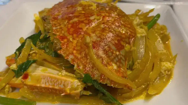 Crab stir-fried in a yellow curry sauce with egg and onion