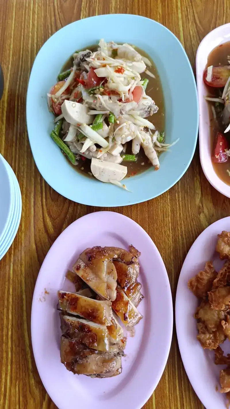 Papaya salad and grilled chicken on the wooden table