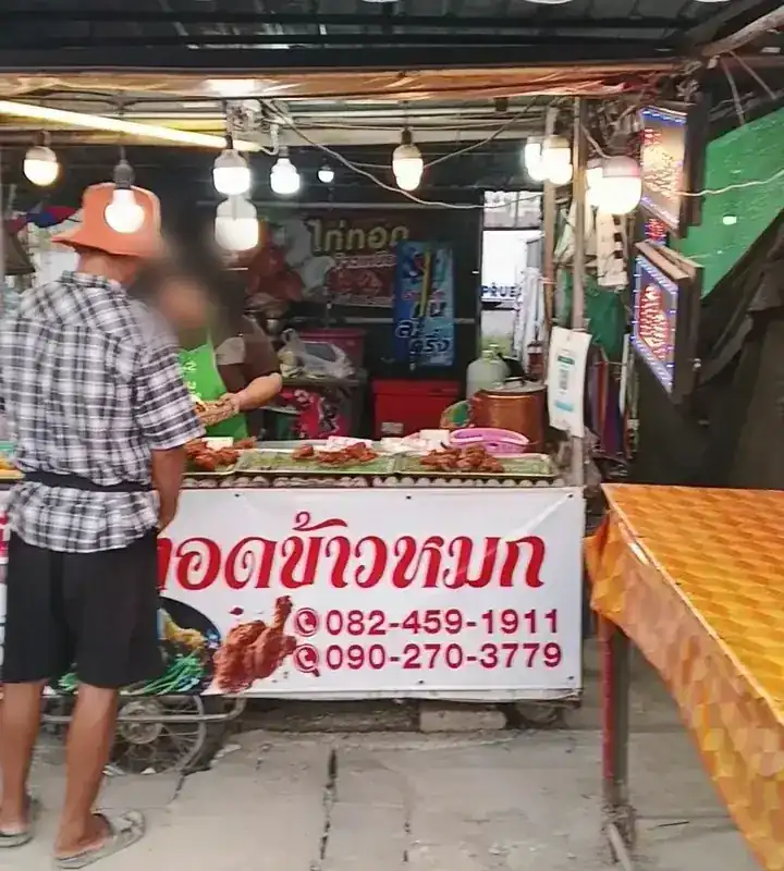 The stall front, with trays of chicken above the red-lettered banner