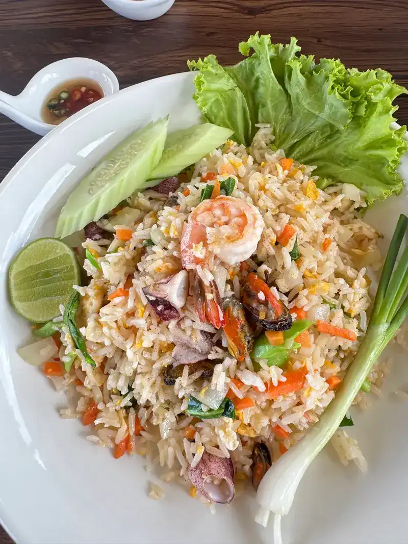 Fried rice with prawn, squid and mussels, served with lime, cucumber, spring onion and a small dish of chilli sauce