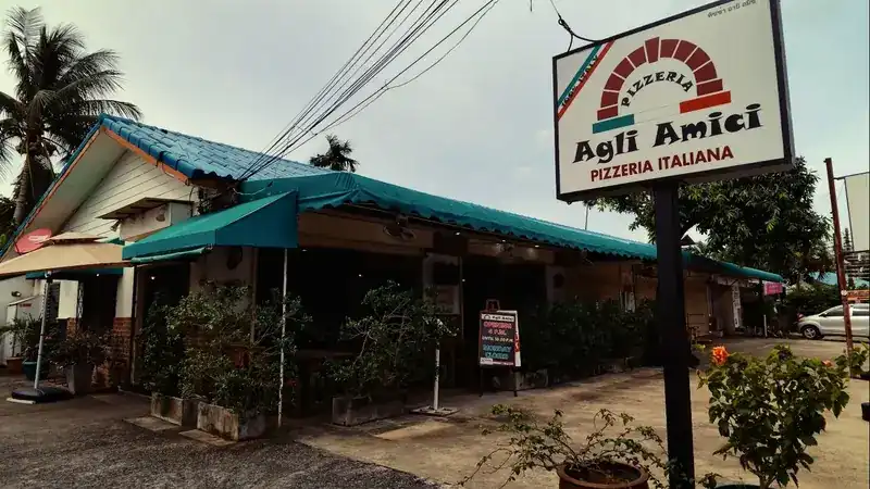 The restaurant from the road: green roof, awning and the Agli Amici signboard