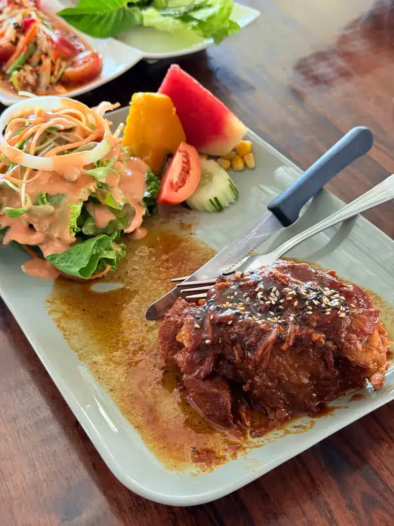 Glazed pork topped with sesame, with salad and fruit