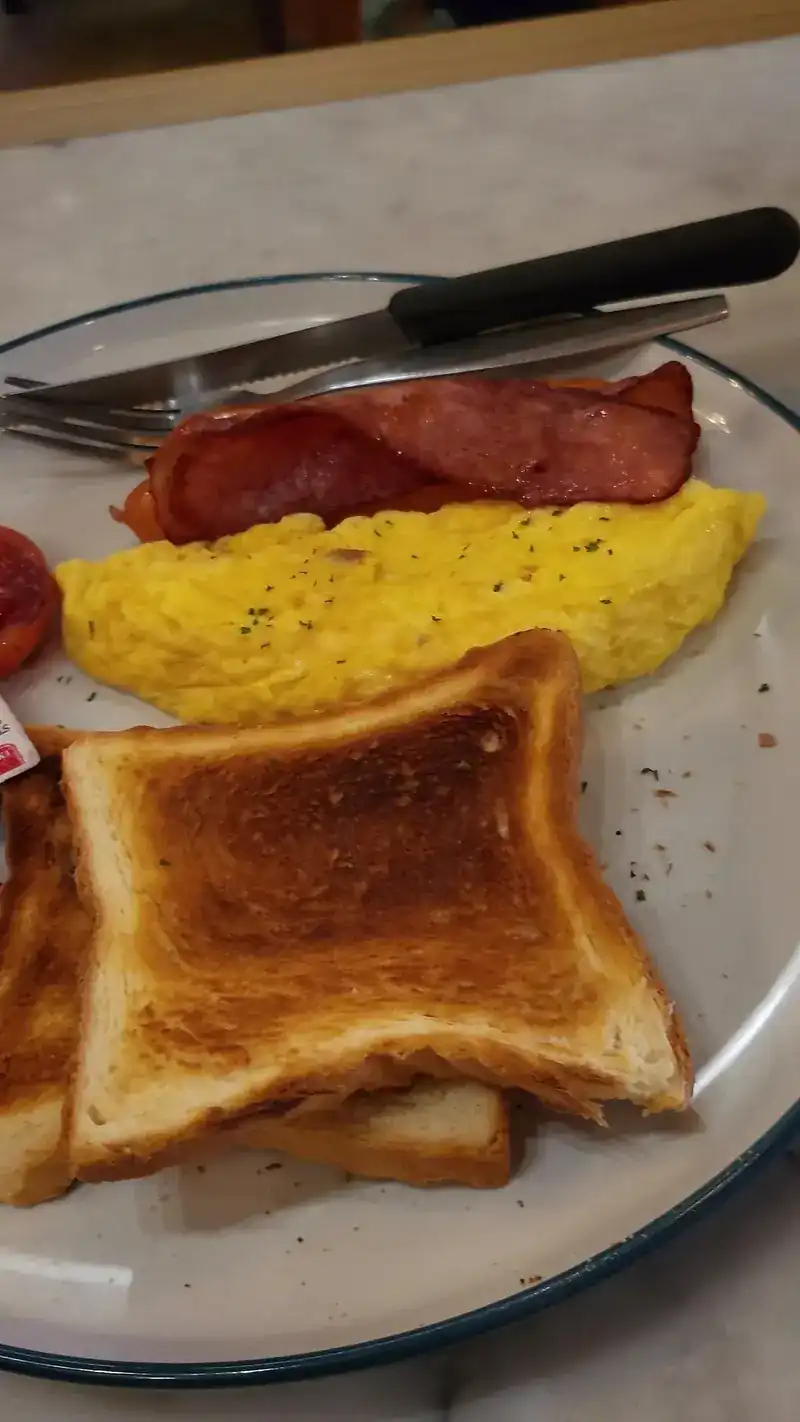Breakfast plate with scrambled eggs, bacon and thick toast