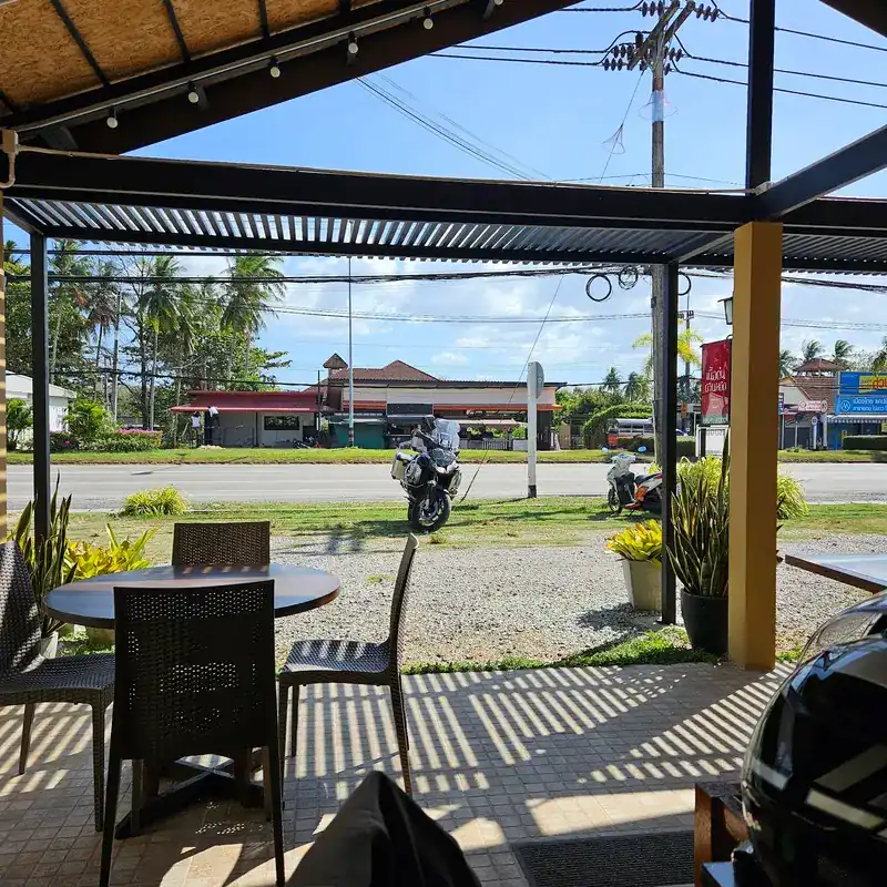 A table on the terrace, looking out to the road and palm trees